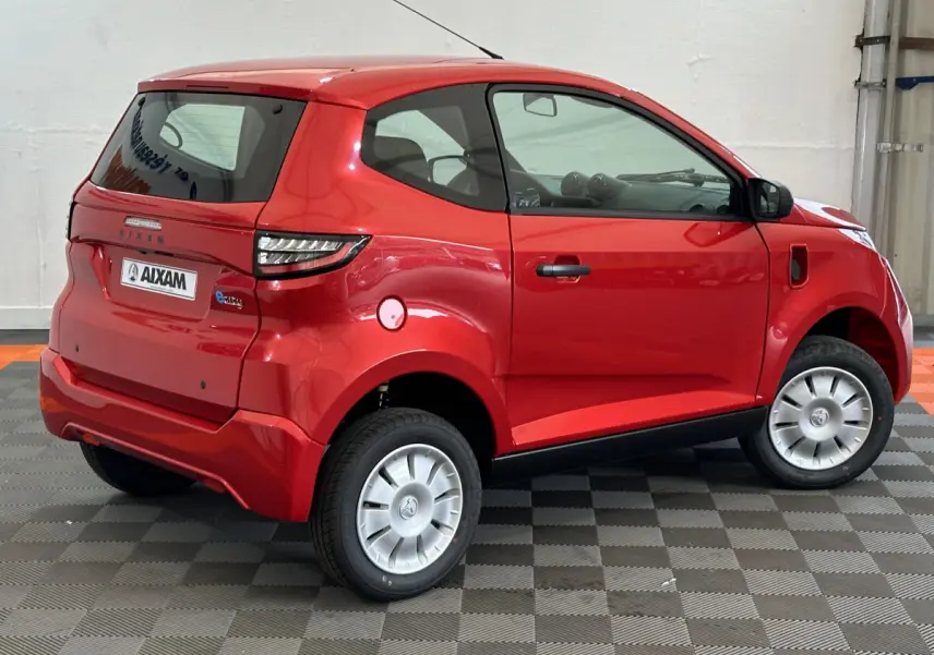 Vue 3/4 arrière droite d'une Aixam Ambition E City Pack rouge électrique avec rétroviseur caméra côté conducteur.