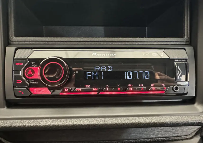 Poste audio Pioneer intégré au tableau de bord d'une Aixam Ambition E City Pack rouge, vue intérieure centrée.