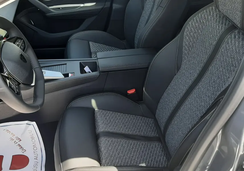 Vue intérieure côté conducteur de la Peugeot 308 gris selenium, sièges tissu et cuir avec surpiqûres contrastées.