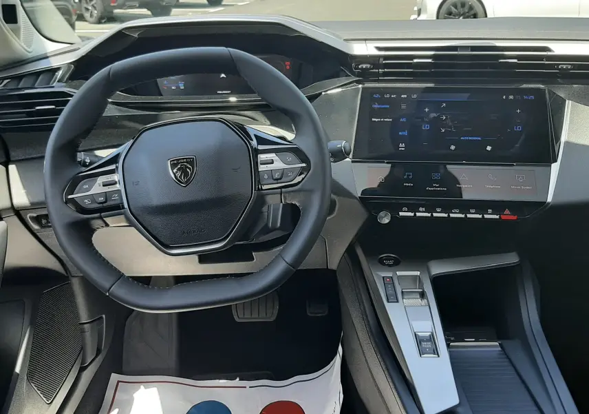 Vue intérieure centrée sur le volant compact et l’écran tactile du tableau de bord du Peugeot 308 gris Selenium 2026.