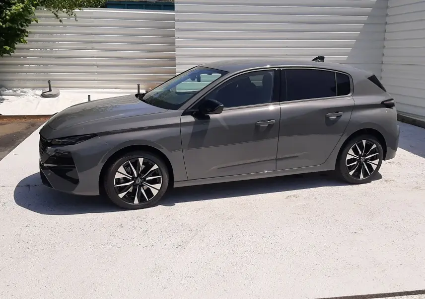 Peugeot 308 gris sélénium vue de profil côté gauche, avec jantes alliage noires et vitres teintées.