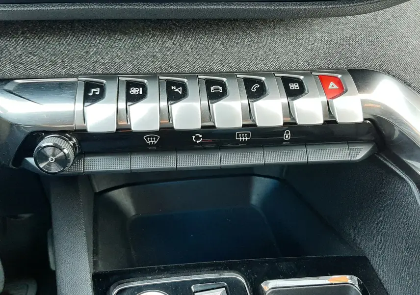 Gros plan sur la console centrale du Peugeot 3008 gris platinium, montrant les boutons de commande et le bouton start/stop.