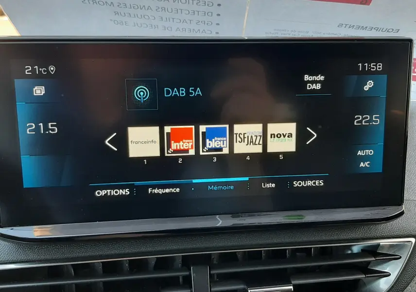 Écran tactile central du Peugeot 3008 2023 affichant les stations radio DAB, avec commandes climatisation et ventilation visibles en dessous.