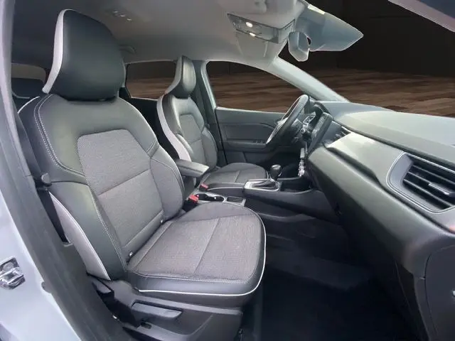 Vue intérieure côté gauche du Renault Captur DCI 115 EDC Intens 2021, sièges tissu gris et cuir noir, tableau de bord moderne.
