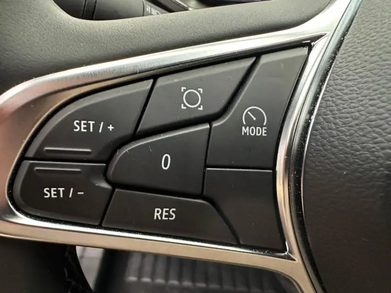 Gros plan sur les commandes noires du volant du Renault Captur 2025, avec boutons de régulateur et mode.