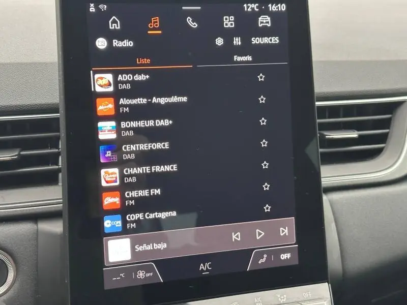 Écran tactile central de la Renault Captur 2025 affichant la liste des radios numériques, intérieur noir.