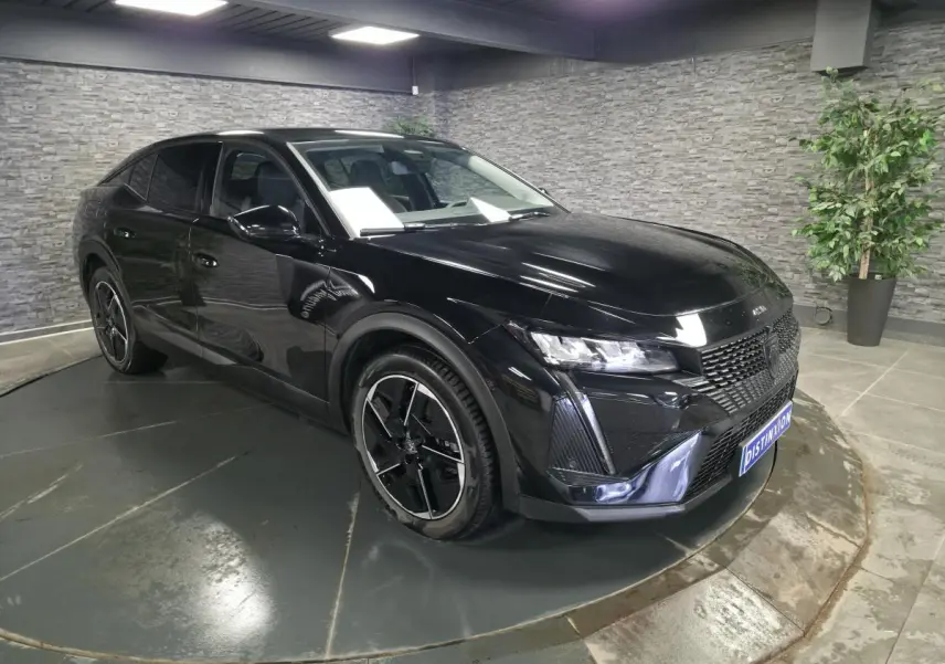 Peugeot 408 électrique noir Perla Nera en 3/4 avant droit, jantes alliage 19 pouces diamantées visibles.