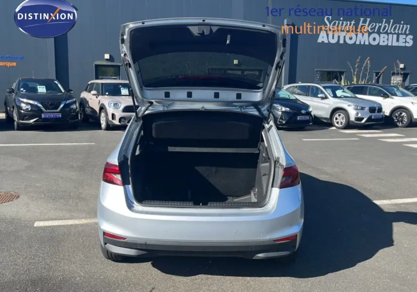 Vue arrière d'une Skoda Fabia 2025 Reflex Silver avec coffre ouvert sur un parking extérieur.