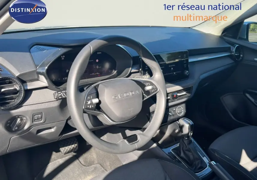 Intérieur de la Skoda Fabia 2025 en vue côté conducteur, tableau de bord gris noir avec volant multifonction et boîte auto.