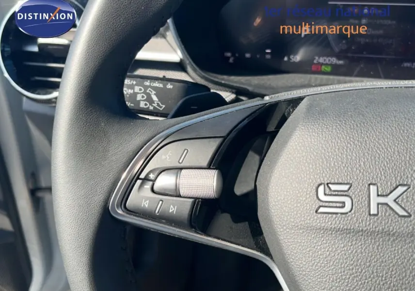 Gros plan sur le volant noir de la Skoda Fabia 2025, montrant les commandes multimédia côté gauche et le tableau de bord digital.