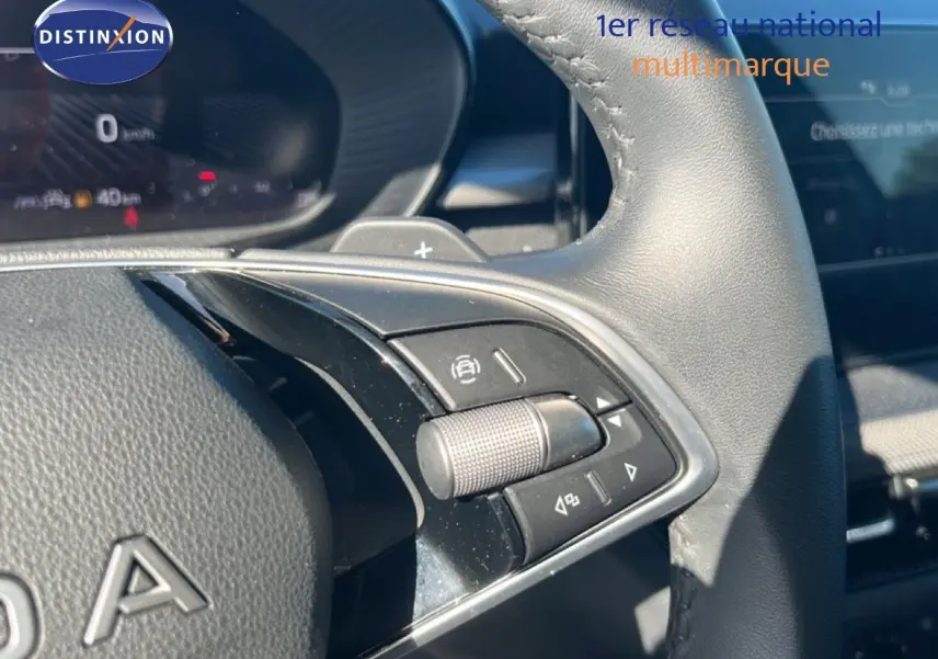 Gros plan sur les commandes au volant en cuir noir de la Skoda Fabia 2025, avec molette et boutons multifonctions visibles.