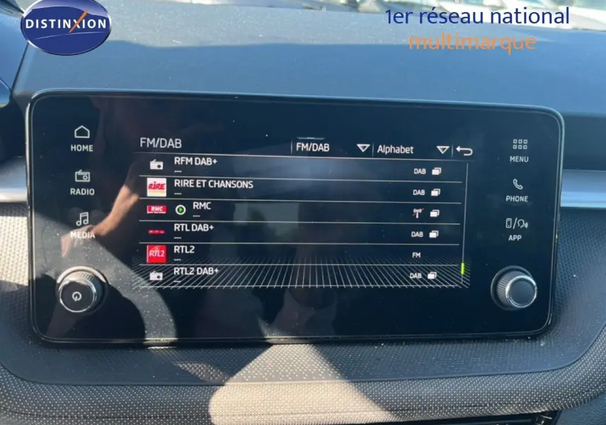 Écran tactile multimédia affichant les stations radio FM/DAB dans l'habitacle d'une Skoda Fabia Reflex Silver.