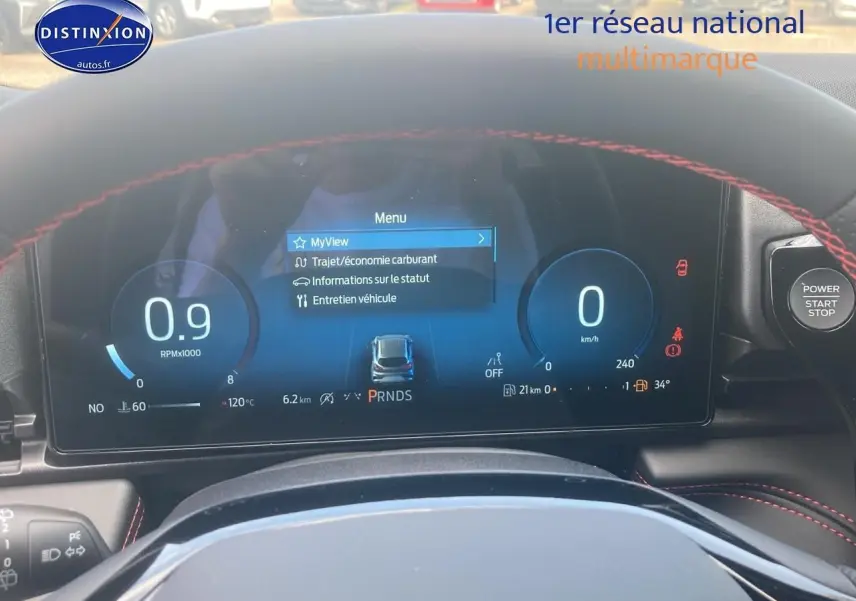 Tableau de bord numérique du Ford Puma 2025 avec affichage du menu et volant avec surpiqûres rouges visibles.