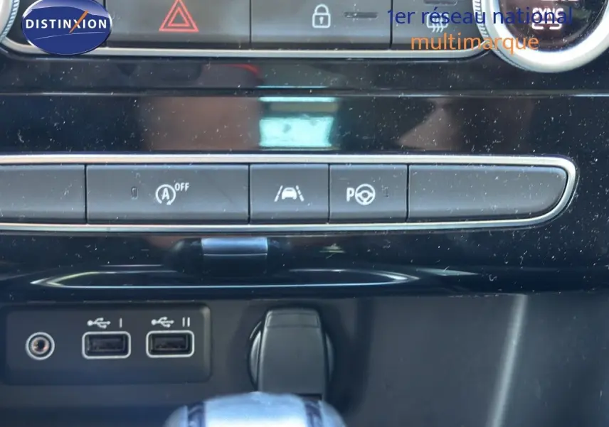 Gros plan sur la console centrale de la Renault Mégane Break gris titanium, montrant les ports USB et commandes de conduite assistée.