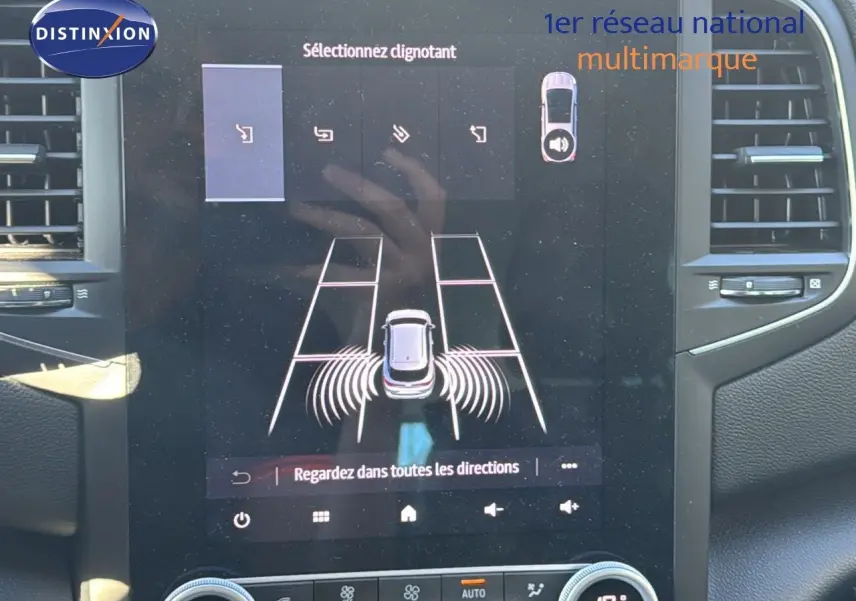 Écran tactile intérieur de la Renault Mégane Break gris titanium montrant l'aide au stationnement et les options de clignotants.