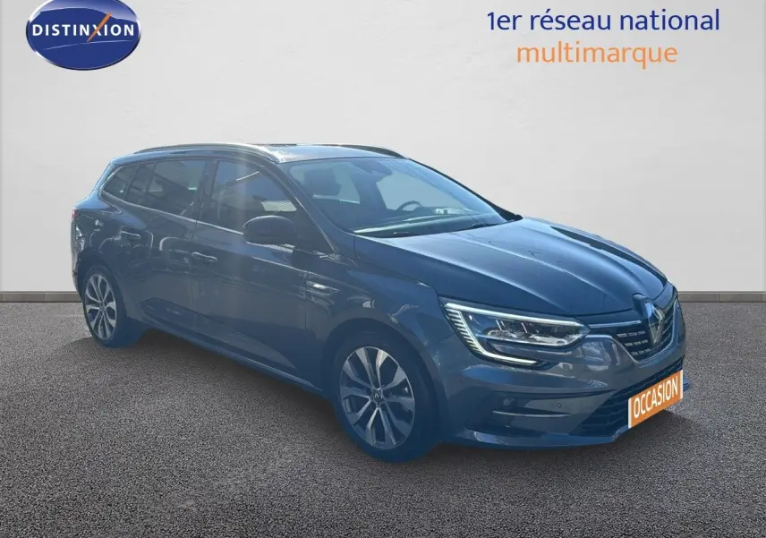 Renault Mégane Break gris titanium métal vue 3/4 avant droit avec phares LED allumés sur fond neutre.