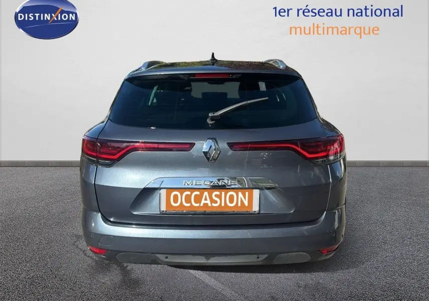 Vue arrière d'une Renault Mégane Break gris titanium métal avec feux LED et logo distinctif au centre.