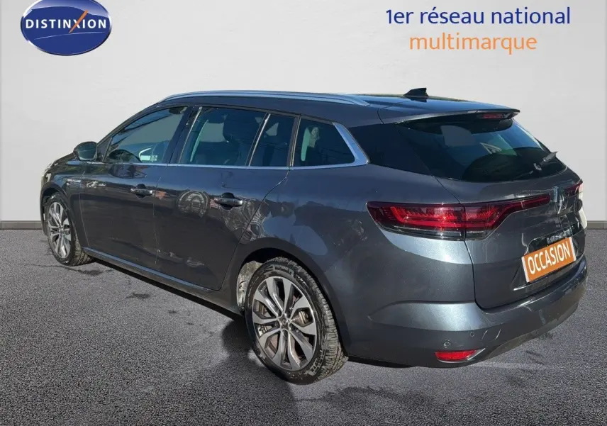Renault Mégane Break gris titanium métal vue 3/4 arrière droit, avec jantes alliage et feux LED distinctifs.