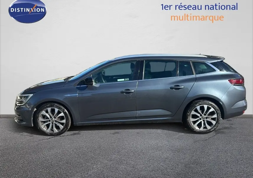 Profil droit d'une Renault Mégane Break gris titanium métal 2024 avec jantes alliage bicolores et vitres teintées.