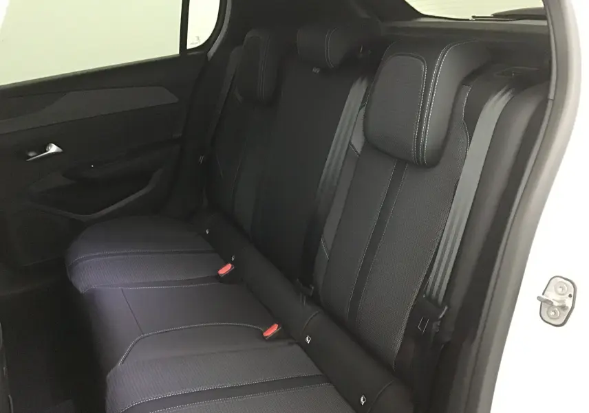 Vue intérieure du siège arrière droit en tissu noir avec surpiqûres blanches d'une Peugeot 308 gris Sellenium 2025.