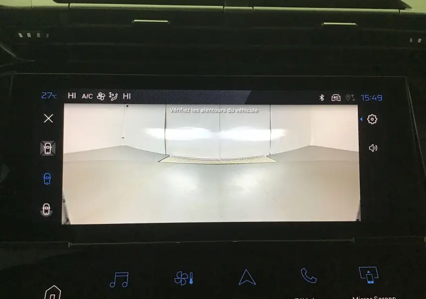 Écran central de la Peugeot 308 gris Sellenium affichant la caméra 360 avec vue arrière du parking intérieur.