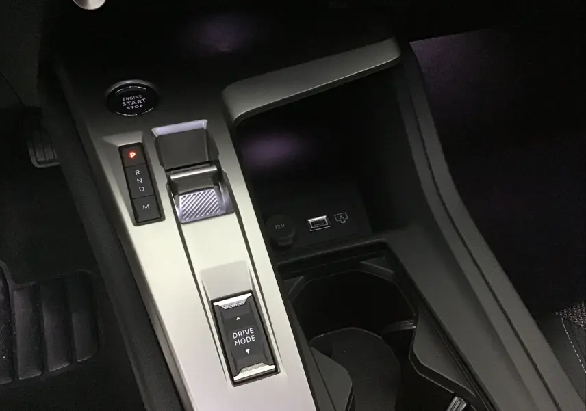 Vue rapprochée de la console centrale grise avec levier de vitesses et bouton start/stop d'une Peugeot 308 2025.