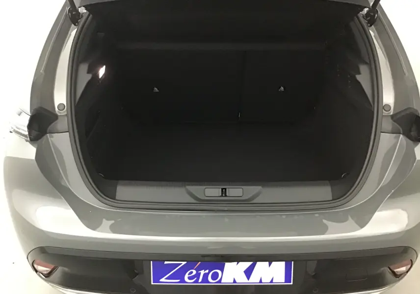 Coffre ouvert vu de l'arrière d'une Peugeot 308 gris Sellenium 2025, soulignant l'espace de chargement vide.