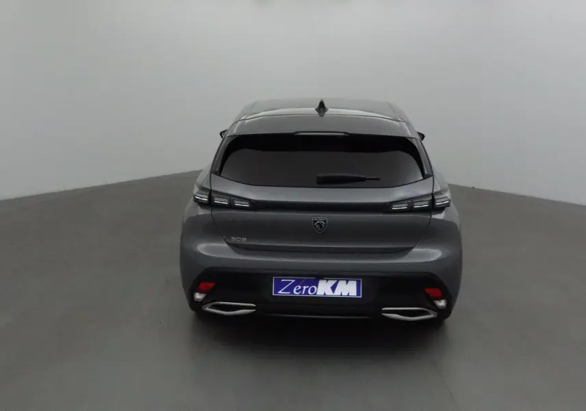 Vue arrière d'une Peugeot 308 gris Sellenium avec feux LED et double sortie d'échappement chromée dans un studio.
