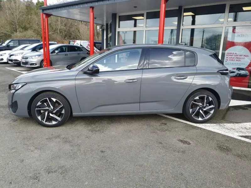 Profil côté gauche d'une Peugeot 308 2024 gris Sélénium avec jantes alliage au design moderne.