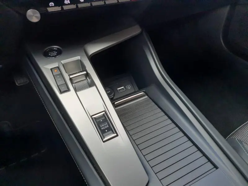 Console centrale avec sélecteur de boîte automatique et bouton start/stop dans l'habitacle gris d'une Peugeot 308 2024