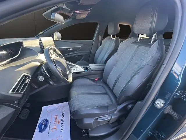 Intérieur avant droit du Peugeot 3008 2023 bleu Célèbes, sièges tissu et cuir, tableau de bord moderne avec écran tactile.
