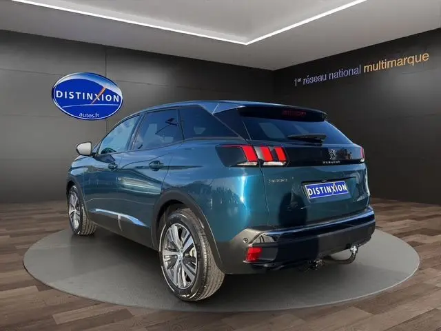 Vue 3/4 arrière droite d'un Peugeot 3008 bleu Célèbes 2023 avec feux arrière à trois griffes et jantes alliage.