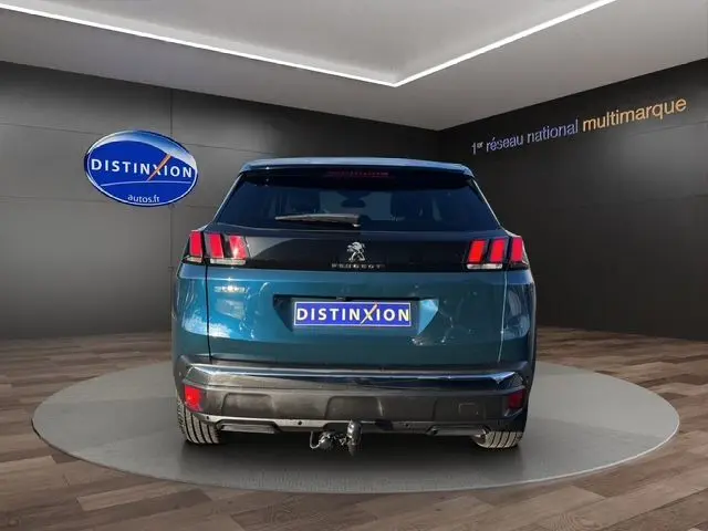 Vue arrière d'un Peugeot 3008 bleu Célèbes 2023 avec feux LED caractéristiques et attelage visible.