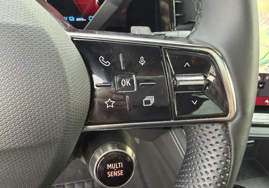 Gros plan sur les commandes au volant en textile grainé noir du Renault Austral E-Tech 2025 avec bouton Multi-Sense.