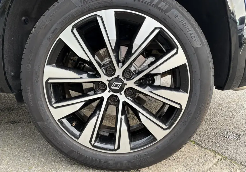 Gros plan sur la jante alliage 19 pouces diamantée noire du Renault Austral E-Tech Bleu Iron, roue avant droite.