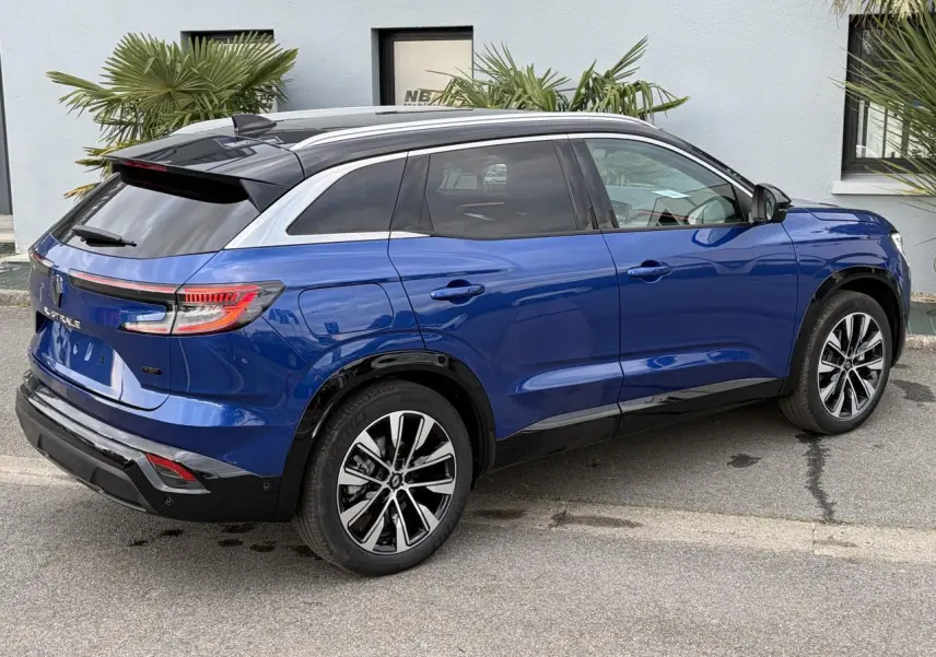 Vue 3/4 arrière droite du Renault Austral E-Tech bleu Iron avec toit noir panoramique et jantes alliage 19 pouces.