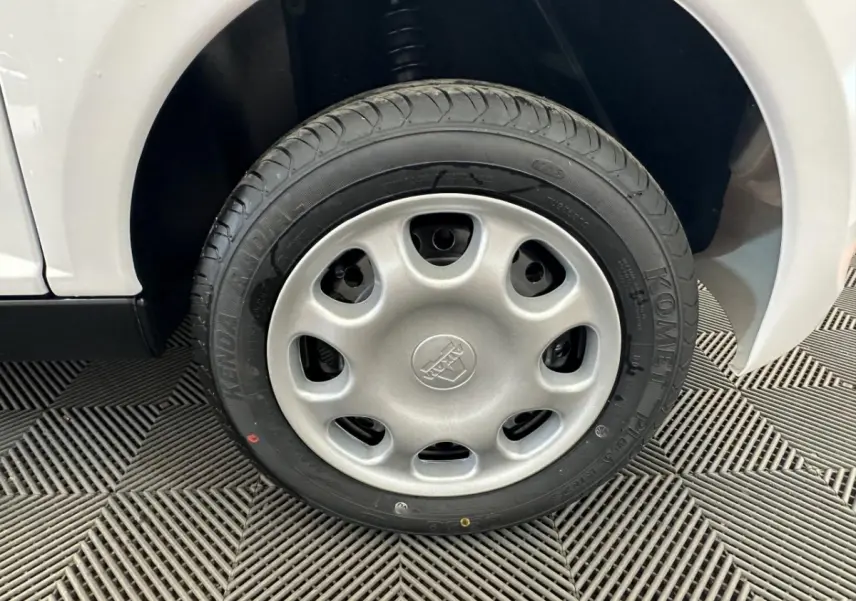 Gros plan sur la roue arrière droite d'une Aixam Minauto E Access blanche 2026 avec pneu Kenda visible.