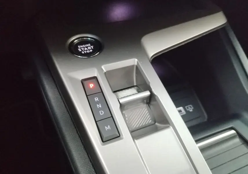 Vue rapprochée de la console centrale grise avec bouton start/stop et commandes de boîte automatique sur Peugeot 308 SW Hybrid.