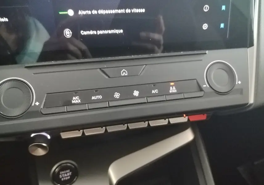 Détail du tableau de bord de la Peugeot 308 SW Hybrid 145 e-DCS6 Allure 2025 en gris Artense, montrant les commandes de climatisation et le bouton start/stop.