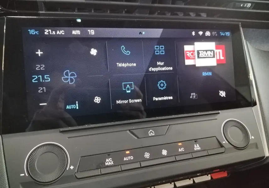 Vue rapprochée de l’écran tactile central et des commandes de climatisation du Peugeot 308 SW Hybrid gris Artense.