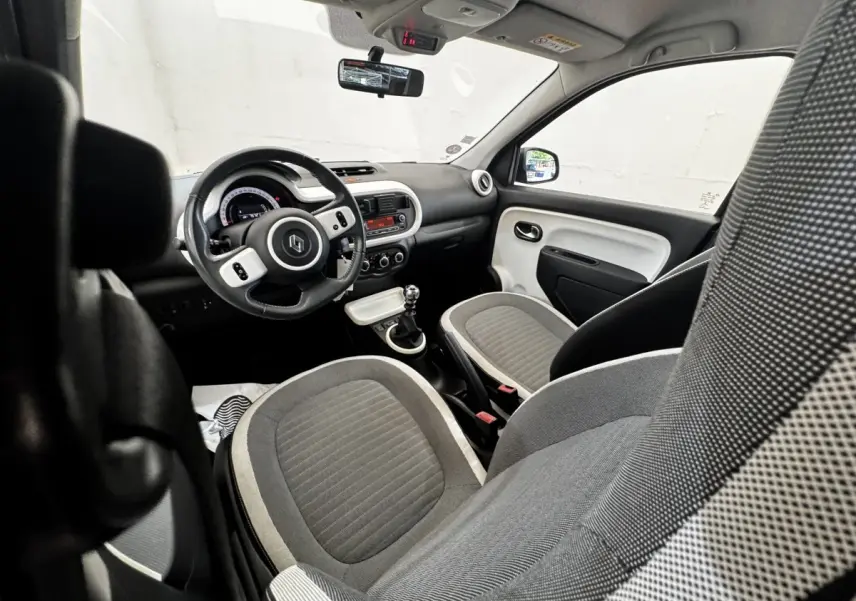 Vue intérieure avant droite de la Renault Twingo Intense Energy TCe 90 avec sièges gris et volant cuir multifonctions.