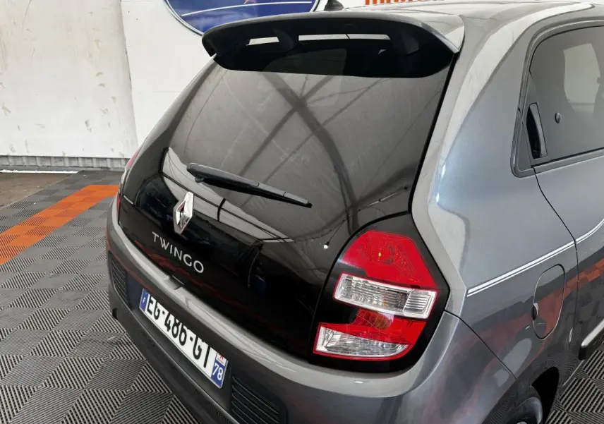 Vue 3/4 arrière droite d'une Renault Twingo Intense Energy TCe 90 gris foncé avec hayon noir et feux arrière rouges.