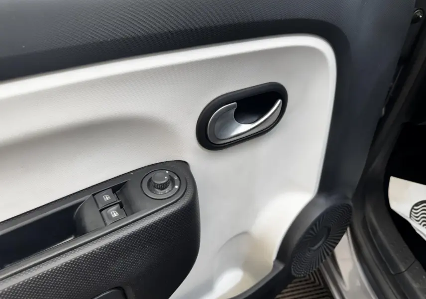Gros plan sur la porte intérieure avant gauche gris clair de la Renault Twingo Intense Energy TCe 90 avec commandes électriques.