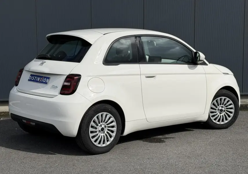 Vue 3/4 arrière droite d'une Fiat 500 électrique blanche Arctic avec feux arrière foncés et jantes multibranches.