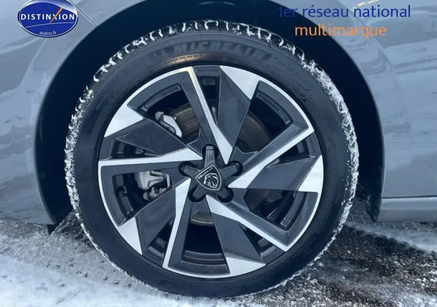 Gros plan sur la jante alu bicolore du côté gauche d'une Peugeot 308 gris sellenium avec traces de neige.