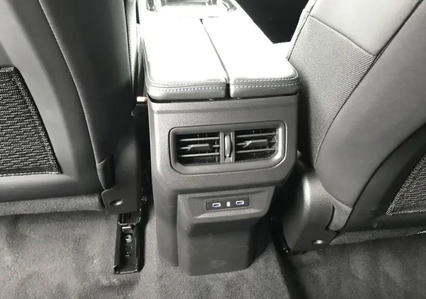 Vue rapprochée de la console centrale arrière du Renault Austral blanc, avec aérateurs et prises USB visibles.