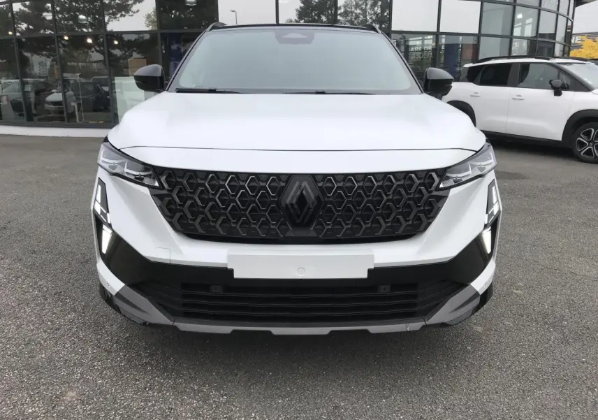 Vue de face du Renault Austral blanc avec calandre noire à motif hexagonal et feux LED en forme de T.