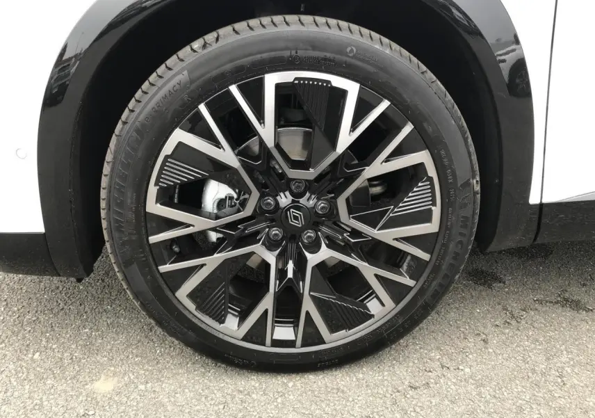 Gros plan sur la jante alliage 20'' noire et argentée du côté gauche d'un Renault Austral blanc QPB GNE.