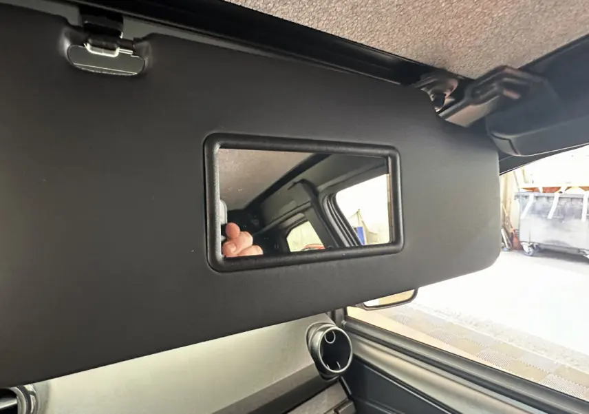 Détail du pare-soleil côté conducteur avec miroir intégré dans l’habitacle d’une Aixam Ambition E City Pack blanche.