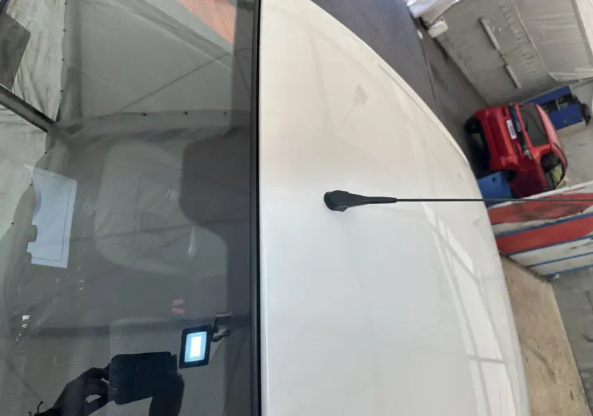 Vue plongeante sur le toit blanc d'une Aixam Ambition E City Pack 2026 avec antenne et rétroviseur caméra côté conducteur.